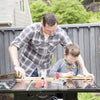 man and kid measuring wood and using contractor saw